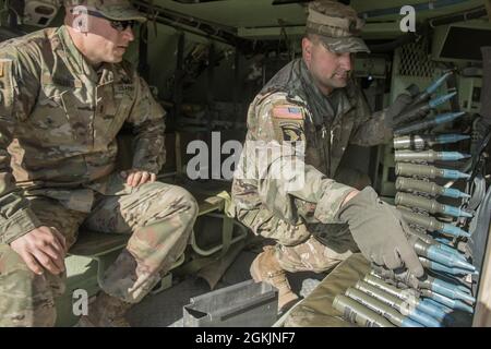 Die Nationalgarde der Idaho-Armee Sgt 1. Klasse Travis Wegner legt die Munitionsauflagen aus, um sie mit 1lt in den Turm zu laden. Todd Sigler beobachtet den Prozess. Charlie Company aus dem 116. Kampfteam der Kavalleriebrigade begann am 1. Mai 2021 das jährliche Training und kehrte am 13. Mai aus dem Orchard Combat Training Center zurück. Die Männer und Frauen von C Company absolvierten eine erfolgreiche und herausfordernde jährliche Schulung im OCTC, bei der Bradley Gunnery Table VI absolviert und 11 Bradley-Crews qualifiziert wurden. Die abtaufenden Infanterieeinheiten absolvierten ihre Qualifikation für alle sechs Kader. Die Trainingsübungen wh Stockfoto