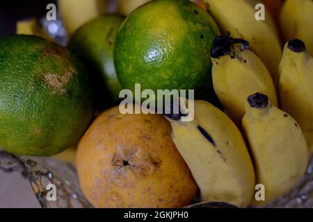 Bananen, Papaya und Orangen in einer Vase in einem Haus. Früchte sind Nahrungsmittel, die reich an Nährstoffen und Substanzen sind, die zur Gesundheit beitragen. Stockfoto