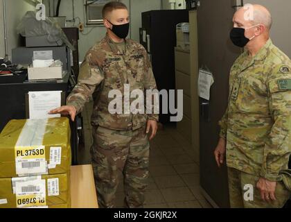 Der 2. LT. Brandon Thurmond, der stellvertretende Ausgabekenner des 175. Financial Management Support Center, führte den australischen Generalmajor, General Christopher A. Field, den stellvertretenden Kommandanten des U.S. Army Central Command, während des Besuchs des Generals am 6. Mai 2021 in der Einheit auf einer Tour durch die 175. FMSC-Einrichtung „The Vault“. Während der Tour stegte Thurmond, ein Absolvent der University of Northern Georgia, zu einem drei-hohen Stapel FedPacks, die jeweils mit 16,000 Millionen, bestehend aus B0.000 Bills, ausgestattet waren. Stockfoto