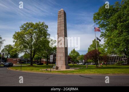 Blick auf die Südseite des Camp Merritt Memorial Monument in Cresskill, N.J., 6. Mai 2021. Der 66 Meter hohe Obelisk, der das Zentrum des Lagers markierte, ist den Soldaten gewidmet, die während des Ersten Weltkriegs durch das Lager einmarschierten, um in Europa zu kämpfen. Auf der Ost- und Westseite des Denkmals sind die Namen der 573 Soldaten, Vier Krankenschwestern und ein Zivilist, die im Lager aufgrund der Grippeepidemie von 1918 ums Leben kamen. Auf der Nordseite ist ein Relief von Robert I. Aitken aus einem doughboy aus dem Ersten Weltkrieg. Direkt davor befindet sich eine dimensionale Steinschnitzkarte von Camp Merritt. Das Denkmal wurde geweiht Stockfoto