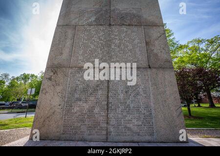 Namensliste auf der Westseite des Camp Merritt Memorial Monument in Cresskill, N.J., 6. Mai 2021. Der 66 Meter hohe Obelisk, der das Zentrum des Lagers markierte, ist den Soldaten gewidmet, die während des Ersten Weltkriegs durch das Lager einmarschierten, um in Europa zu kämpfen. Auf der Ost- und Westseite des Denkmals sind die Namen der 573 Soldaten, Vier Krankenschwestern und ein Zivilist, die im Lager aufgrund der Grippeepidemie von 1918 ums Leben kamen. Auf der Nordseite ist ein Relief von Robert I. Aitken aus einem doughboy aus dem Ersten Weltkrieg. Direkt davor befindet sich eine dimensionale Steinschnitzkarte von Camp Merritt. Das Monument war es Stockfoto