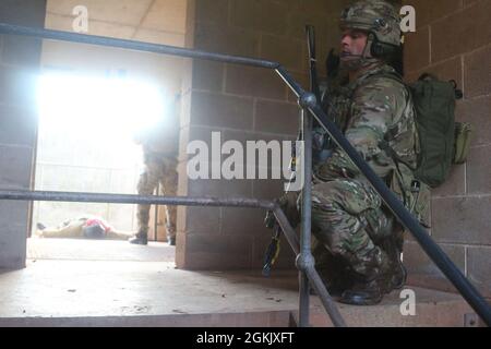 Ein Soldat der britischen Armee 4 Gewehre, zieht Sicherheit während eines Angriffs auf ein Ziel in einem Trainingsgebiet in Brecon, Großbritannien. Das Training war Teil der gemeinsamen Übung „Bold Legion“, die die beiden Teams zusammenbrachte, um die Grundlage für eine kontinuierliche Beziehung zu schaffen. Stockfoto