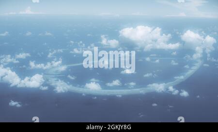 Luftaufnahme einer riesigen runden Koralleninsel, umgeben von blauem Meerwasser, mit vielen kleinen Stratocumulus-Wolken am schönen Himmel mit sichtbarem h Stockfoto