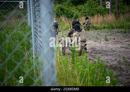 Studenten des 820. Kurses Tactical Leader der Base Defence Group besprechen ihren nächsten Schritt während einer Patrouille auf der Luftwaffenbasis Moody, Georgia, 10. Mai 2021. Im Trainingsszenario suchte die Truppe auf Patrouille nach einem Waffenlager und reagierte dann auf den Kontakt. Der Kurs „Taktischer Anführer“ vermittelt Führungskräften die Einsatzplanung, die Führung und die Taktik kleiner Einheiten sowie die kritischen Fähigkeiten für die integrierte Basisverteidigung. Stockfoto