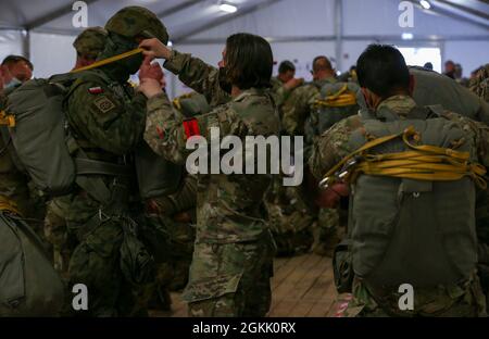 Ein US-Armeesoldat, der 82. Luftbrigade zugeordnet ist, führt eine Jumpmaster-Fallschirmuntersuchung für einen polnischen Soldaten durch, der während der Swift Response 21 auf dem Mihail Kogalniceanu Air Base, Rumänien, am 10. Mai 2021 dem 16. Luftbataillon zugeordnet wurde. Swift Response 21 ist eine mit Defender 21 verknüpfte Übung, eine jährliche, von der US-Armee geführte, multinationale, gemeinsame Übung, die darauf ausgelegt ist, Bereitschaft und Interoperabilität zwischen den USA, der NATO und den Partnermilitärs aufzubauen. Stockfoto