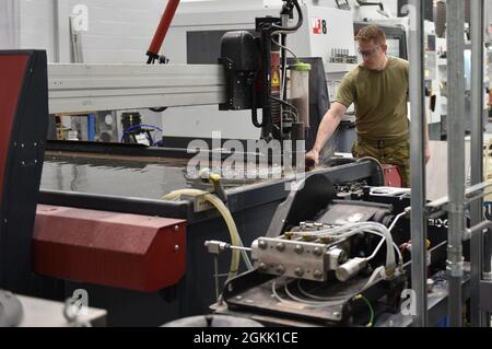 Master-Sgt. Michael Howard, Flugzeugmetalltechniker des 911. Maintenance Squadron-Fertigungsfluges, nimmt während des Kalibrierungsprozesses des Wasserstrahlschneidwerkzeugs an der Pittsburgh International Airport Air Reserve Station, 10. März 2021, Anpassungen an einem Metallhalteblock vor. Automatisierte Werkzeuge ermöglichen es den Technikern, die Produktivität in der Werkstatt zu steigern, wenn Teile mit gleichbleibender Genauigkeit in weniger Zeit hergestellt werden als bei manuellen Produktionsmethoden. Stockfoto