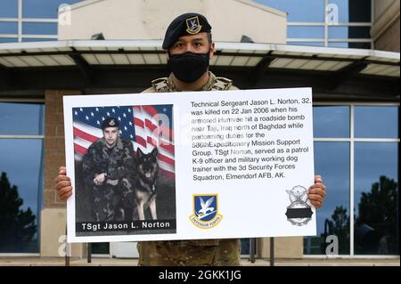 Ein Flieger der 460. Sicherheitskräfte-Staffel hält ein Plakat auf der Buckley Air Force Base, Colorado, am 10. Mai 2021 hoch, das die Geschichte des 1. LT. Joseph D. Helton, eines Verteidigers der 732. Sicherheitskräfte-Staffel, enthält, der während seiner Tätigkeit als Flight Commander getötet wurde. Während der National Police Week würdigten die Sicherheitskräfte-Luftwaffe ihre Brüder und Schwestern, die ihr Leben im Dienst für die Sicherheit und den Schutz anderer verloren haben. Stockfoto