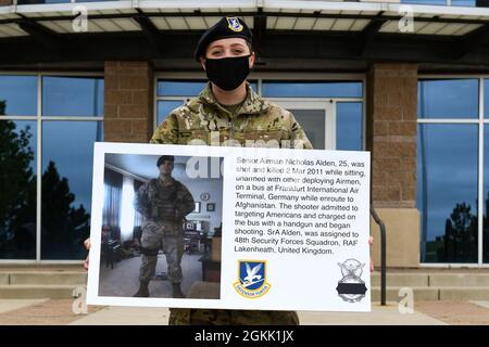 Ein Flieger der 460. Staffel der Sicherheitskräfte hält ein Plakat auf dem Luftwaffenstützpunkt Buckley, Colorado, am 10. Mai 2021, mit der Geschichte des Senior Airman Nichola Alden, eines 43. Verteidigers der Sicherheitskräfte, der auf dem Weg nach Afghanistan getötet wurde. Während der National Police Week würdigten die Sicherheitskräfte-Luftwaffe ihre Brüder und Schwestern, die ihr Leben im Dienst für die Sicherheit und den Schutz anderer verloren haben. Stockfoto