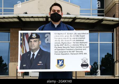 Ein Flieger der 460. Staffel der Sicherheitskräfte hält ein Plakat auf dem Luftwaffenstützpunkt Buckley, Colorado, am 10. Mai 2021 hoch, das die Geschichte des Senior Airman Nathan C. Sartain, eines 66. Geschwaderverteidigers der Sicherheitskräfte, enthält, der bei einem Flugzeugabsturz getötet wurde. Während der National Police Week würdigten die Sicherheitskräfte-Luftwaffe ihre Brüder und Schwestern, die ihr Leben im Dienst für die Sicherheit und den Schutz anderer verloren haben. Stockfoto