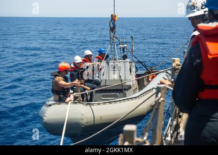 210510-N-FD648-1044 ROTES MEER (10. Mai 2021) – Matrosen, die dem Lenkraketen-Zerstörer USS Mahan (DDG 72) zugewiesen wurden, heben während Kleinbootoperationen im Roten Meer, 10. Mai, ein starres, aufblasbares Boot auf. Mahan wird in den Einsatzbereich der 5. US-Flotte eingesetzt, um Marineinteraktionen zu unterstützen, um die maritime Stabilität und Sicherheit in der Zentralregion zu gewährleisten und das Mittelmeer und den Pazifik durch den westlichen Indischen Ozean und drei strategische Engpässe zu verbinden. Stockfoto