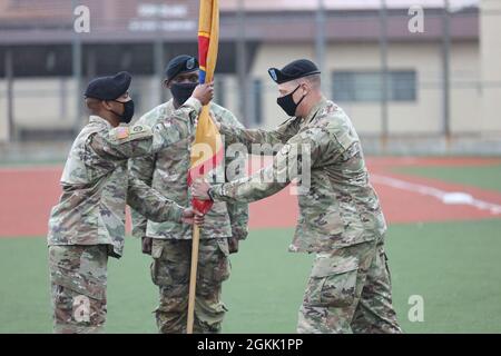 Brig. General Steven Allen, Kommandant des 19. Expeditionary Sustainment Command, übergibt die Befehlsfarben an Sgt. Maj. Larry Cuffie, NCOIC of Ceremony, während einer Zeremonie zur Übergabe der Verantwortung für Command Sgt. Maj. LaDerek Green, Mitte, über Camp Walker, Republik Korea. Stockfoto