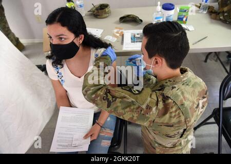 Pvt. Alyssa Hovland, 996. Area Support Medical Company, Kampfmediziner, verwaltet die COVID-19-Impfung an ein Stammesmitglied der Tohono O’odham Nation in Why, Arizona, 11. Mai 2021. Die Arizona National Guard hat sich mit dem Stamm zusammen gemacht, um Impfungen zu leisten und auch als Übersetzer für die überwiegend spanischsprachige Gemeinschaft zu fungieren. Stockfoto