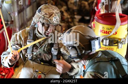 Ein Fallschirmjäger der US-Armee, der dem Ingenieur-Bataillon der 6. Brigade, dem Kampfteam der 4. Infanteriebrigade (Airborne), der 25. Infanteriedivision der US-Armee in Alaska, zugewiesen wurde, spricht mit dem Senior Airman Klayton Curran, einem Loadmaster, der dem 9. Spezialeinsatzgeschwader in New Mexico vor einer Zwangseintrittsoperation in der Nähe von Ft. Greely, Alaska während der Northern Edge 2021. Etwa 15,000 US-Dienstmitglieder nehmen an einer gemeinsamen Trainingsübung Teil, die vom 3. Bis 14. Mai 2021 von den US Pacific Air Forces auf und über dem Joint Pacific Alaska Range Complex, dem Golf von Alaska und temporären Seeakteen veranstaltet wird Stockfoto