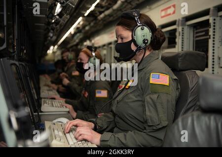 Technik. Sgt. Brittany Sizemore-Cecchini, 97. Geheimdienstgeschwader, sitzt an einem Computer, der ihre Aufgaben während des Fluges am Lincoln Airport, Nebr., 11. Mai 2021 simuliert. Flieger von verschiedenen Offutt Air Force Base, Nebrar, Schwadronen posierten für Fotos auf einem RC-135V/W Nietgelenk. Stockfoto