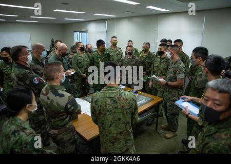 Capt. Christopher Ramos, ein Verbindungsoffizier mit der III Marine Expeditionary Force, informiert die Anführer und Truppen jeder Truppe über die bevorstehenden Entwicklungen für die Übung Jeanne D’Arc 21, Camp Ainoura, Sasebo, Japan, 12. Mai, 2021. Während der Mitarbeiterübung teilen sich die Führungskräfte jeder Kraft die Planungsverfahren zur Vorbereitung auf die Durchführung von Feldschulungen. ARC-21 bietet den US-amerikanischen, französischen, japanischen und australischen Streitkräften die Möglichkeit, Erfahrungen, Taktiken und Best Practices auszutauschen, um ihre Fähigkeiten gemeinsam zu verbessern. Stockfoto