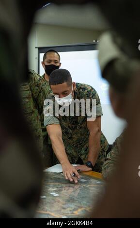 Capt. Christopher Ramos, ein Verbindungsoffizier mit der III Marine Expeditionary Force, informiert die Anführer und Truppen jeder Truppe über die bevorstehenden Entwicklungen für die Übung Jeanne D’Arc 21, Camp Ainoura, Sasebo, Japan, 12. Mai, 2021. Während der Mitarbeiterübung teilen sich die Führungskräfte jeder Kraft die Planungsverfahren zur Vorbereitung auf die Durchführung von Feldschulungen. ARC-21 bietet den US-amerikanischen, französischen, japanischen und australischen Streitkräften die Möglichkeit, Erfahrungen, Taktiken und Best Practices auszutauschen, um ihre Fähigkeiten gemeinsam zu verbessern. Stockfoto