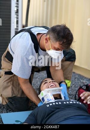 LAGER LEMONNIER, Dschibuti (12. Mai 2021) Sgt. Katherine Jimenez aus Naugatuck, Connecticut, erhält medizinische Versorgung von einem EMT für simulierte Verletzungen während einer Basisübung im Camp Lemonnier, 12. Mai 2021. Die Schulungsveranstaltung, bei der ein Erdbeben simuliert wurde, testete eine Vielzahl von Menschen in ihrem Wissen und Protokoll, wie sie Patienten während eines tatsächlichen Massenverlustrefalls ordnungsgemäß evakuieren und behandeln können. Stockfoto