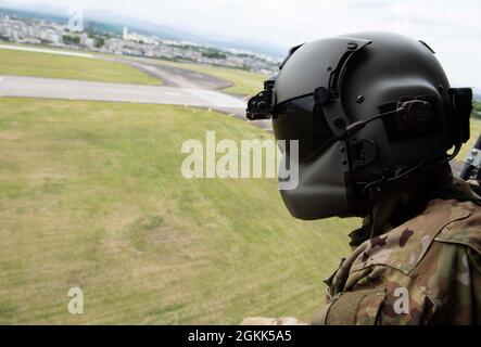 Personal Sgt. Zach Webster, Flugingenieur der 459. Airlift Squadron, scannt während eines Rescue Rodeo-Events über der Yokota Air Base, Japan, 12 den Boden nach Truppen vor einem UH-1N Iroquois-Hubschrauber 2021. Such- und Rettungsübungen wie das Rescue Rodeo bereiten Airmen darauf vor, schnell und sicher auf Notfallszenarien in unvorhersehbaren Situationen zu reagieren. Stockfoto