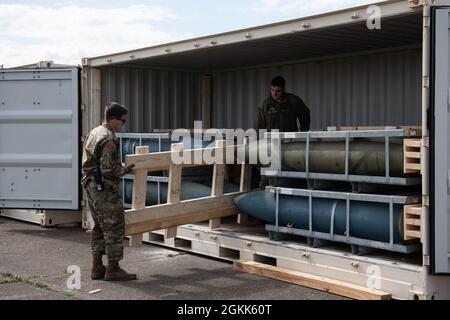 US Air Force Staff Sgt. Kyle Scharer und Airman 1st Class John Ellis mit 48th Munitions Squadron laden einen Transportcontainer bei der Royal Air Force Lakenheath, England, 13. Mai 2021. Die 48th MUNS verteilte einsatzfähige und nicht einsatzfähige Vermögenswerte, um einkommende Munitionsmittel für die F-35A Lightning II unterzubringen Stockfoto