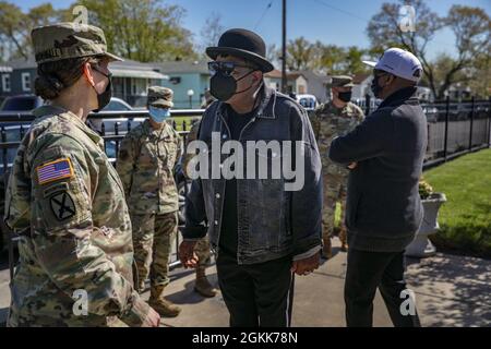 Die Oberin der US-Armee, Ellen Shannon-Ball, links, der Offizier, der für das Community Impfzentrum (CVC) an der ehemaligen Roosevelt High School in Gary, Indiana, verantwortlich ist, spricht mit Tito Jackson, dem Zentrum, im Jackson-Familienhaus, gegenüber vom staatlich geführten, staatlich unterstützten Gary CVC, 13. Mai 2021. Jeder US-Luftwaffenflieger und Soldat der US-Armee, der sich mit den Jackson-Brüdern Marlon und Tito traf, wurden geimpft, zusammen mit den Brüdern selbst, und sie alle zeigten ihre Unterstützung für den Gary CVC durch eine Ankündigung des öffentlichen Dienstes, an der sie zusammen mit dem Federal Emergency M teilnahmen Stockfoto