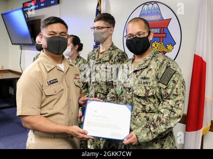 YOKOSUKA, Japan (13. Mai 2021) ADM hinten. Butch Dollaga, Kommandant der Submarine Group 7 (CSG7), überreicht dem Elektroniktechniker der 1. Klasse, Michael Perry, gebürtiger Groton, Connecticut, die Medaille der Marine und des U.S. Marine Corps für die rasche Behebung einer kritischen Fehlfunktion der Ausrüstung auf dem Wachturm. CSG7 leitet U-Boot-Aktivitäten im gesamten westlichen Pazifik, im Indischen Ozean und im Arabischen Meer: Zwei U-Boot-Schiffe, USS Frank Cable (AS 40) und USS Emory S. Land (AS 39), fünf Überwachungsschiffe mit gezogenen Array-Sensoren und drei ozeanographische Untersuchungsschiffe, wenn sie für t beauftragt wurden Stockfoto