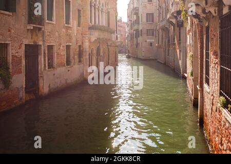 VENEDIG, ITALIEN - OKTOBER 08 2017: Gondel auf dem schmalen Kanal (Rio de San Luca) mit Sonneneinstrahlung auf der Wasseroberfläche in Venedig, Italien. Stockfoto