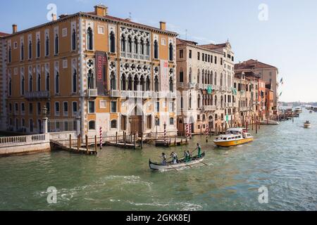 VENEDIG, ITALIEN - OKTOBER 08 2017 Palazzo Cavalli-Franchetti und Canal Grande von Ponte dell'Accademia, Venedig, Italien. Das Ruderer-Team auf den Bootszügen auf dem Canal Grande Stockfoto