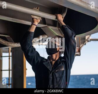 210513-N-XR893-0020 ATLANTISCHER OZEAN (13. Mai 2021) Seaman Jeremy Archer aus South Hill, Washington, verwendet Sandpapier, um Korrosion an einer Trinkwasserleitung auf der Fantail des Flugzeugträgers USS Harry S. Truman der Nimitz-Klasse (CVN 75) zu entfernen. Truman verließ die Norfolk Naval Shipyard, nachdem er eine 10-monatige, regelmäßig geplante, erweiterte Verfügbarkeit der Fluggesellschaft abgeschlossen hatte. Während der Verfügbarkeit unterzog sich das Schiff der Wartung, Reparatur und Inspektion verschiedener Ausrüstung, darunter Engineering, Kampfsysteme und nuklearer Antrieb. Stockfoto