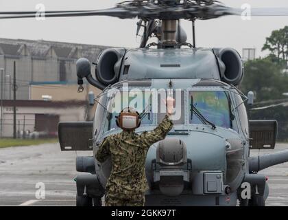 210513-N-VI040-1432 MARINEFLUGPLATZ ATSUGI, Japan (13. Mai 2021) Ein Seemann leitet den Piloten eines Sikorsky MH-60R 'Seahawk' Hubschraubers, der den 'Warlords' des Hubschrauber Maritime Strike Squadron FIVE ONE (HSM 51) zugewiesen wurde, nachdem er auf der Fluglinie an Bord der Naval Air Facility (NAF) Atsugi, Japan, 13. Mai 2021, landete. Die Warlords, die in der NAF Atsugi eingesetzt werden, bieten kampfbereite, bewaffnete, gegen die Oberfläche und gegen Unterseeboot abwehrende Helikopterabteile für Schiffe, die im westlichen Pazifik und im Arabischen Golf eingesetzt werden. Stockfoto