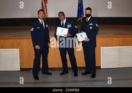 Technische Abteilung der US-Luftwaffe Antoine Nguyen, 54 Entwicklungsflug des Lufttankergeschwaders NCOIC, überreicht Stipendien des First Sergeants Council des Luftwaffenstützpunkts Altus (AAFB) an Technical Sgt. Andre Miles, 97. Logistics Readiness Squadron einseitige Ausbildung der Flugbesatzung NCOIC und Staff Sgt. Cristhian Roldan, 97. Air Mobility Wing Religious Affairs Airman am Community College of the Air Force (CCAF) Abschlusszeremonie auf der AAFB, Oklahoma, 13. Mai 2021. Laut seiner offiziellen Website vergibt die CCAF über 22,000 Mitarbeiter in angewandten Wissenschaften aus 71 Studiengängen überhaupt Stockfoto