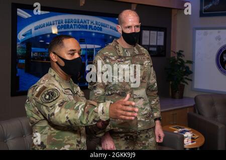 SCHRIEVER AFB, Colorado - Master Sgt. Herbert McDonald, Joint Task Force-Space Defense NCOIC Operations Integration Division, führt den Chief Master Sgt. John Ebbrecht, Senior Enlisted Advisor der National Geospatial-Intelligence Agency, erklärte während seines Besuchs bei der Organisation am 13. Mai 2021 auf dem Luftwaffenstützpunkt Schriever, Colo. McDonald, einige der Meilensteine der Organisation seit der Gründung des National Space Defense Center im Jahr 2015, damals das Joint Interagency Combined Space Operations Center genannt. Stockfoto