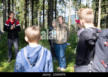 Baiersbronn, Deutschland. August 2021. Erzieherin Svenja Fox (m) begrüßt die Junior Rangers zu einem Ausflug mit Übernachtung. Kinder im Alter von fünf bis zwölf Jahren können Junior Rangers im Nationalpark sein. In kleinen Gruppen lernen sie die Grundlagen über Natur und Tiere, später lernen sie über die Kologie, warum der Nationalpark existiert und wie man sich mit Karte und Kompass orientiert. Quelle: Philipp von Ditfurth/dpa/Alamy Live News Stockfoto