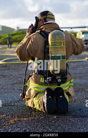 Ein Feuerwehrmann des 142. Flügels der Oregon Air National Guard nimmt an einer Live-Feuerübung mit Marine Corps-Feuerwehrleuten auf der Marine Corps Base, Hawaii, 14. Mai 2021 Teil. Dieser Brand ist Teil einer größeren gemeinsamen Übung, die das Einlernen von Flugzeugen, Ausstiegsschulungen sowie die gemeinsame Schulung und Betreuung weniger erfahrener Feuerwehrleute umfasst. Stockfoto