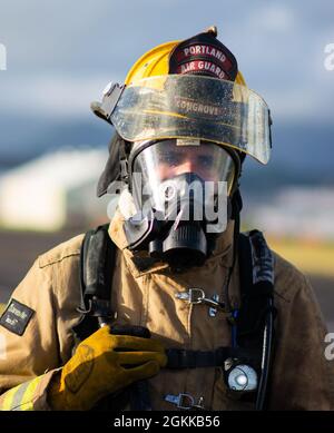 Personal Sgt. Dylan Congrove, ein Feuerwehrmann des 142. Flügels der Oregon Air National Guard, nimmt an einer Live-Feuerübung mit Marine Corps-Feuerwehrleuten auf der Marine Corps Base, Hawaii, 14. Mai 2021 Teil. Dieser Brand ist Teil einer größeren gemeinsamen Übung, die das Einlernen von Flugzeugen, Ausstiegsschulungen sowie die gemeinsame Schulung und Betreuung weniger erfahrener Feuerwehrleute umfasst. Stockfoto