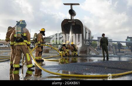 Feuerwehrleute des 142. Flügels der Oregon Air National Guard führen eine Live-Feuerübung mit Marine Corps-Feuerwehrleuten auf der Marine Corps Base, Hawaii, 14. Mai 2021 durch. Dieser Brand ist Teil einer größeren gemeinsamen Übung, die das Einlernen von Flugzeugen, Ausstiegsschulungen sowie die gemeinsame Schulung und Betreuung weniger erfahrener Feuerwehrleute umfasst. Stockfoto