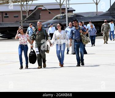 Col. Raul Rosario, Kommandant des 149. Kampfflügels, geht über die Fluglinie zu seinem F-16 Fighting Falcon mit seiner Familie für seinen letzten Flug auf der Joint Base San Antonio-Lackland, Texas, 14. Mai 2021. Traditionell sprühen Freunde, Familie und Mitarbeiter den Piloten beim endgültigen Ausstieg aus dem Flugzeug in Wasser und einer Flasche Champagner nieder. (Fotos der Air National Guard von Mindy Bloem) Stockfoto