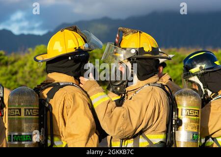 Feuerwehrleute des 142. Flügels der Oregon Air National Guard führen eine Live-Feuerübung mit Marine Corps-Feuerwehrleuten auf der Marine Corps Base, Hawaii, 14. Mai 2021 durch. Dieser Brand ist Teil einer größeren gemeinsamen Übung, die das Einlernen von Flugzeugen, Ausstiegsschulungen sowie die gemeinsame Schulung und Betreuung weniger erfahrener Feuerwehrleute umfasst. Stockfoto