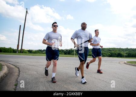 US Air Force Airman 1st Class Jonathan Peterson (links), Master Sgt. Rufus Dixon (Mitte) und Airman 1st Class Chandler Montgomery, alle aus dem 802. Sicherheitskräfte-Geschwader, laufen mit dem gefallenen Schlagstock auf die Retreat-Zeremonie für die National Police Week, 14. Mai 2021, in der Joint Base San Antonio-Lackland, Texas. Der Stab wurde am 8. Mai um 0001 Uhr im JBSA-Fort Sam Houston in Bewegung gesetzt. Die Veranstaltung wurde entworfen, um die Last zu tragen und nie die ultimativen Opfer zu vergessen, die von Verteidigern, Polizeibeamten und jenen, die im Dienst starben, gemacht wurden. Die Freiwilligen geben eine Stunde ihrer Ti Stockfoto