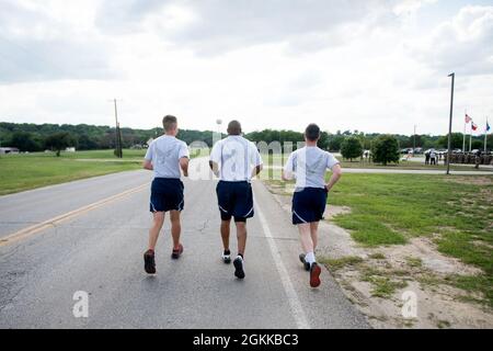 U.S. Air Force Peterson Airman 1st Class Chandler Montgomery (links), Master Sgt. Rufus Dixon (Mitte) und Airman 1st Class Jonathan, alle aus dem 802. Sicherheitskräfte-Geschwader, laufen mit dem gefallenen Schlagstock zur Retreat-Zeremonie für die National Police Week, 14. Mai 2021, auf der Joint Base San Antonio-Lackland, Texas. Der Stab wurde am 8. Mai um 0001 Uhr im JBSA-Fort Sam Houston in Bewegung gesetzt. Die Veranstaltung wurde entworfen, um die Last zu tragen und nie die ultimativen Opfer zu vergessen, die von Verteidigern, Polizeibeamten und jenen, die im Dienst starben, gemacht wurden. Die Freiwilligen geben eine Stunde ihrer Ti Stockfoto