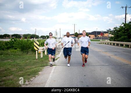 US Air Force Airman 1st Class Jonathan Peterson (links), Master Sgt. Rufus Dixon (Mitte) und Airman 1st Class Chandler Montgomery, alle aus dem 802. Sicherheitskräfte-Geschwader, laufen mit dem gefallenen Schlagstock auf die Retreat-Zeremonie für die National Police Week, 14. Mai 2021, in der Joint Base San Antonio-Lackland, Texas. Der Stab wurde am 8. Mai um 0001 Uhr im JBSA-Fort Sam Houston in Bewegung gesetzt. Die Veranstaltung wurde entworfen, um die Last zu tragen und nie die ultimativen Opfer zu vergessen, die von Verteidigern, Polizeibeamten und jenen, die im Dienst starben, gemacht wurden. Die Freiwilligen geben eine Stunde ihrer Ti Stockfoto