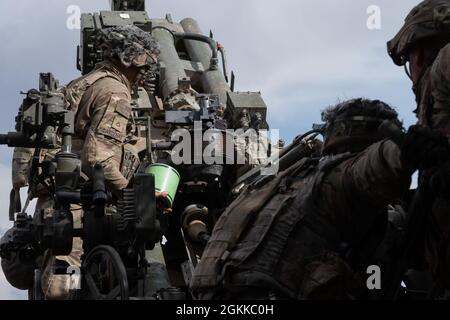 Soldaten, die Charlie Battery, 2. Bataillon, 12. Artillerieregiment, 1. Stryker Brigade Combat Team, 4. Infanterie-Division zugewiesen sind, laden eine M777 Haubitze während Artillerietabelle XII, Fort Carson, Colorado, 14. Mai 2021. Die Artillerietabellen sorgten dafür, dass Kanonenteams Artillerieleaufgaben als Teams ausführen konnten. Stockfoto