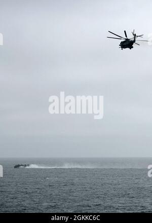 210514-N-OI940-1122 NORDSEE (14. Mai 2021) Ein CH-53-Hengsthubschrauber, der an Marine Medium Tiltrotor Squadron (VMM) 162 (verstärkt) befestigt ist, fliegt in Richtung Landing Craft, Air Cushion (LCAC) 5, der Assault Craft Unit (ACU) 4 zugewiesen, während des Routinefluges und des Brunnendecks, 14. Mai 2021. San Antonio ist in der Nordsee mit dem Amphibiengeschwader 4 und der 24. Marine Expeditionary Unit (24. MEU) als Teil der Iwo Jima Amphibious Ready Group tätig. Stockfoto