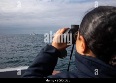 210515-N-QI061-0059 BRITISCHE INSELN (15. Mai 2021) Seaman Michell Bencosne aus New York City beobachtet während Álvaro der Übung At-Sea Demo/2021 von Shield, 15. Mai, die britischen Inseln vom Brückenflügel des Arleigh-Burke-Klasse-Raketenjäger USS Paul Ignatius (DDG 117). Exercise at-Sea Demo/Formidable Shield, ist eine gemeinsame Live-Fire-Übung zur integrierten Luft- und Raketenabwehr (IAMD), die von den Marinestreik- und Unterstützungseinheiten der NATO im Auftrag der Sechsten US-Flotte durchgeführt wird. Stockfoto