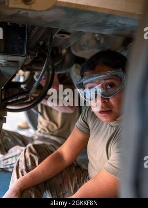 Spc. Johana Martinez, Bodenmechanikerin der Headquarters Support Company, 640. Aviation Support Bataillon, inspiziert die Unterseite eines Fahrzeugs in Camp Buehring, Kuwait, während sie zur Unterstützung der Operation Inhärent Resolve und der Operation Spartan Shield eingesetzt wird. Stockfoto