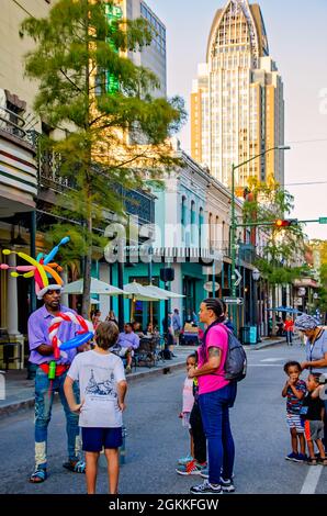 Ein Mann stellt auf der Dauphin Street während des zweiten Freitags-Kunstspaziergangs am 10. September 2021 in Mobile, Alabama, Ballontiere für Kinder her. Stockfoto