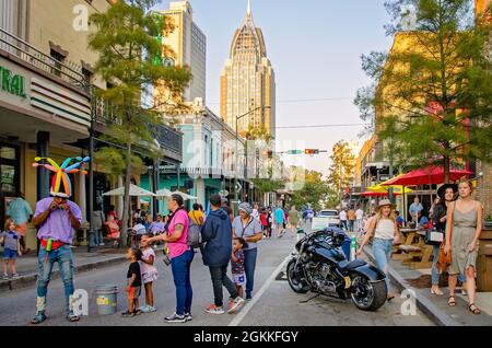 Ein Mann stellt auf der Dauphin Street während des zweiten Freitags-Kunstspaziergangs am 10. September 2021 in Mobile, Alabama, Ballontiere für Kinder her. Stockfoto