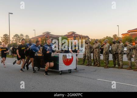 Dogface-Soldaten des Spezialtruppen-Bataillons, der 3. Sustainment Brigade und der 3. Infanterie-Division drücken ihr dekoriertes Bett während des Bettrennen in Fort Stewart, Georgia, am 17. Mai 2021 in Richtung Ziellinie. Das Bettrennen beginnt in dieser Marne-Woche und stellt eine unterhaltsame Alternative zum traditionellen Teilungslauf dar. Stockfoto