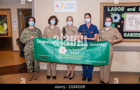 Capt. Lisa Mulligan, Kommandant des Naval Medical Center Portsmouth (NMCP), überreicht den DAISY Award an Kimberly Roquemore, eine Krankenschwester, die für die Labor and Delivery Station (4M) registriert ist. Von links, LT. Cmdr. Natalie Mills, 4KL Division Officer, Capt. Mulligan, Capt. Dixie Aune, NMCP Chief Nursing Officer, Kimberly Roquemore, und Capt. Melissa Austin, NMCP Executive Officer. Als ältestes, kontinuierlich operierendes Militärkrankenhaus der US-Marine seit 1830 dient das Naval Medical Center Portsmouth stolz ehemaligen und gegenwärtigen Militärmitgliedern und ihren Familien. Die national gefeierten, Stockfoto