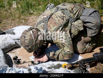 FORT DRUM, N.Y. – CPL der US-Armee. Dakoatah Miller, ein Infanterist mit dem 2. Bataillon der New Yorker Nationalgarde, dem 108. Infanterie-Regiment, stellt Punkte auf einer Militärkarte als Teil der 10. Mountain Division Expert Infantryman Badge-Bewertung in Fort Drum, N.Y., 17. Mai 2021 dar. Zehn Infanteriesoldaten und ein Sanitäter aus dem Kampfteam der 27. Infanteriebrigade nahmen an der fünftägigen Prüfung Teil, um die begehrten Abzeichen „Expert Infantryman“ und „Expert Field Medical“ zu erhalten. Stockfoto