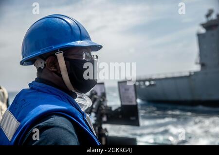 210517-N-XU073-1113 SÜDCHINESISCHES MEER (17. Mai 2021) – Boatswains Mate 2nd Class Branham Daniel aus Dalton, Georgia, steht für eine Auffüllung auf See mit dem Flottennachfüller Henry J. Kaiser USNS Big Horn (T-AO 198) an Bord der Arleigh Burke-Klasse des Lenkraketen-Zerstörers USS Curtis Wilbur (DDG 54). Curtis Wilbur ist Kommandant der Task Force 71/Destroyer Squadron (DESRON) 15, der größten vorwärtseingesetzten DESRON der Marine und der wichtigsten Surface Force der 7. US-Flotte. Stockfoto